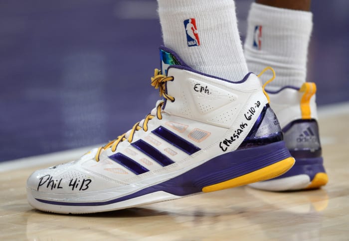 View of white and purple adidas shoes.